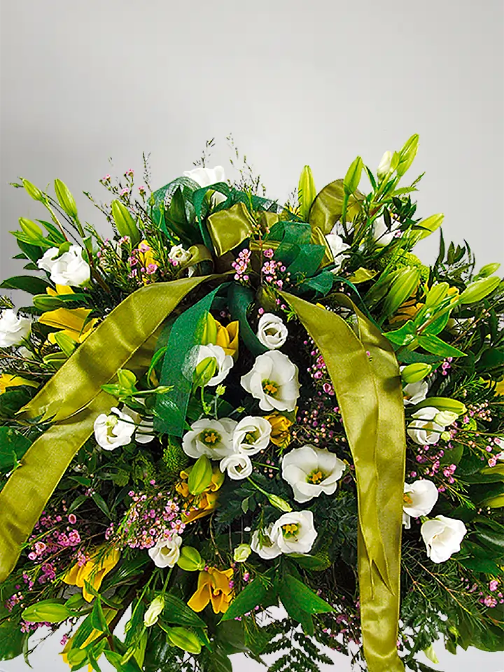 Composizione funebre di lisianthus bianchi e lilium gialli close up